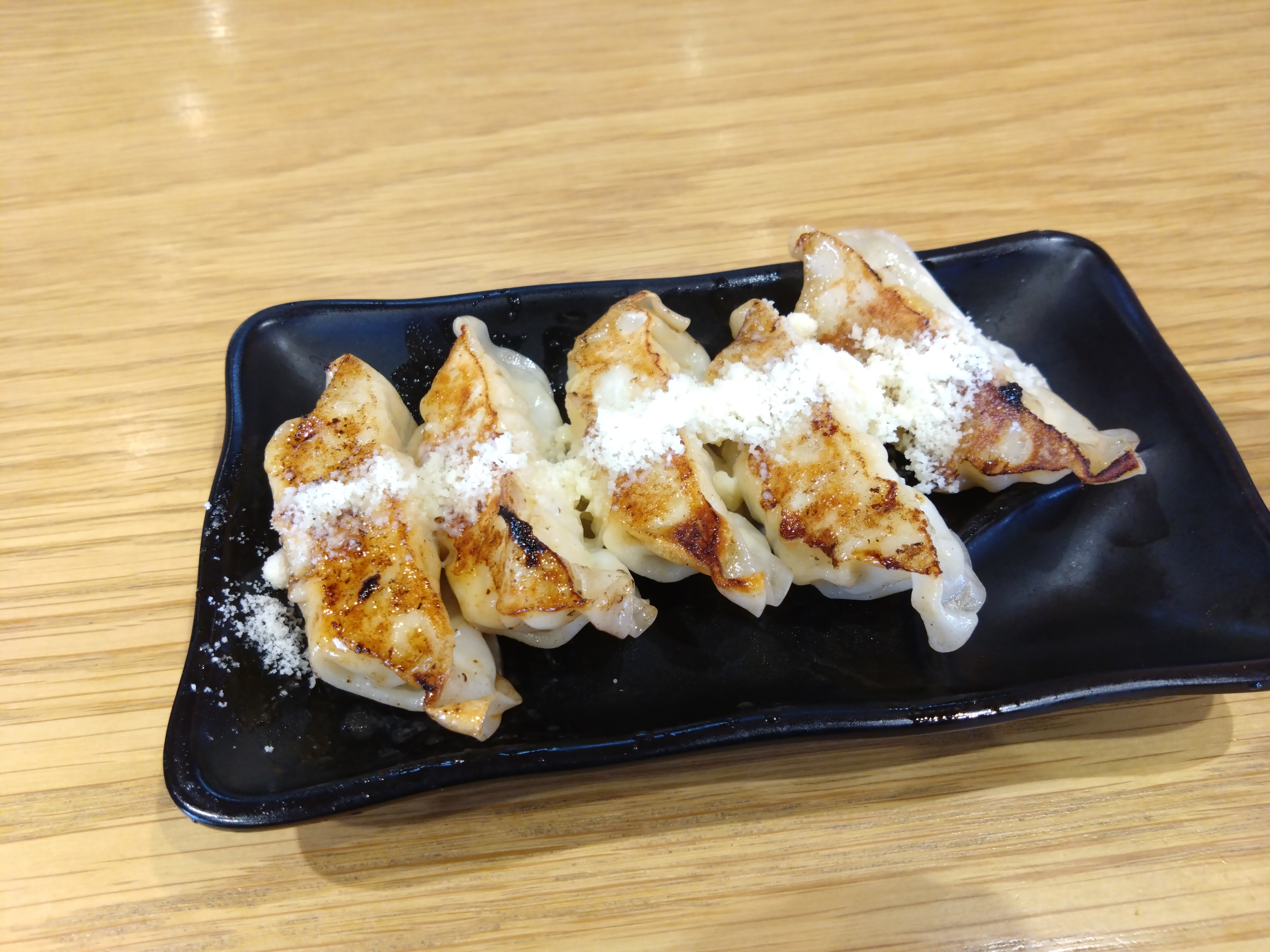 焦げ目のついた餃子が皿に盛られている